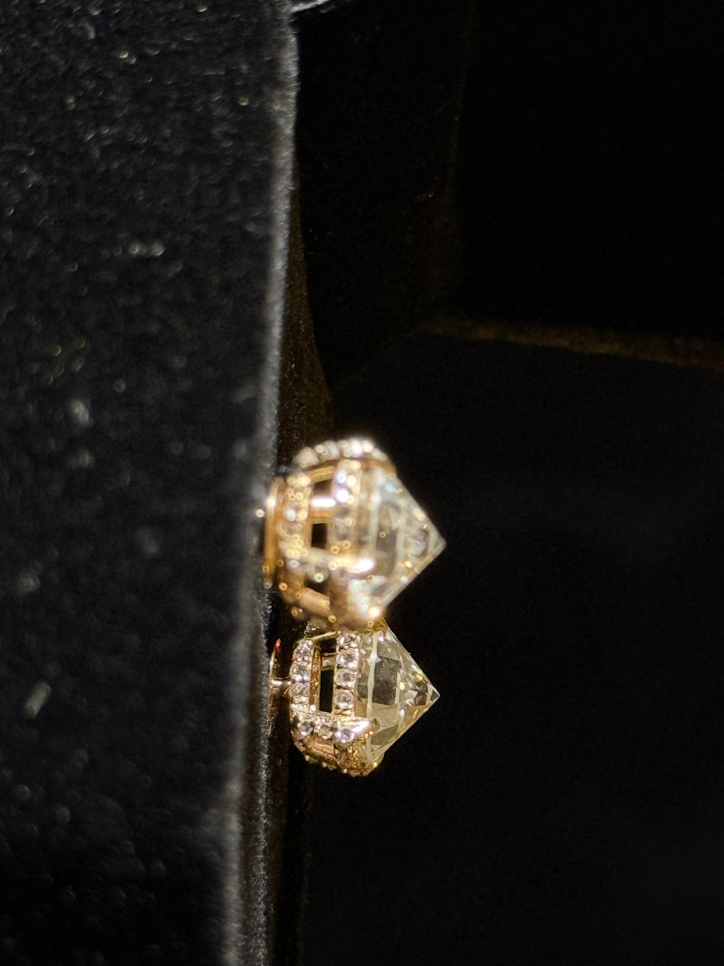 Gold earrings with diamonds on a black background